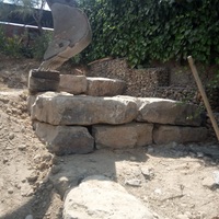 Construcció de mur de contenció de rocalla amb funció de jardinera