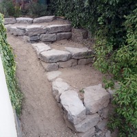 Construcció de mur de contenció de rocalla amb funció de jardinera