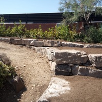 Construcció de mur de contenció de rocalla amb funció de jardinera